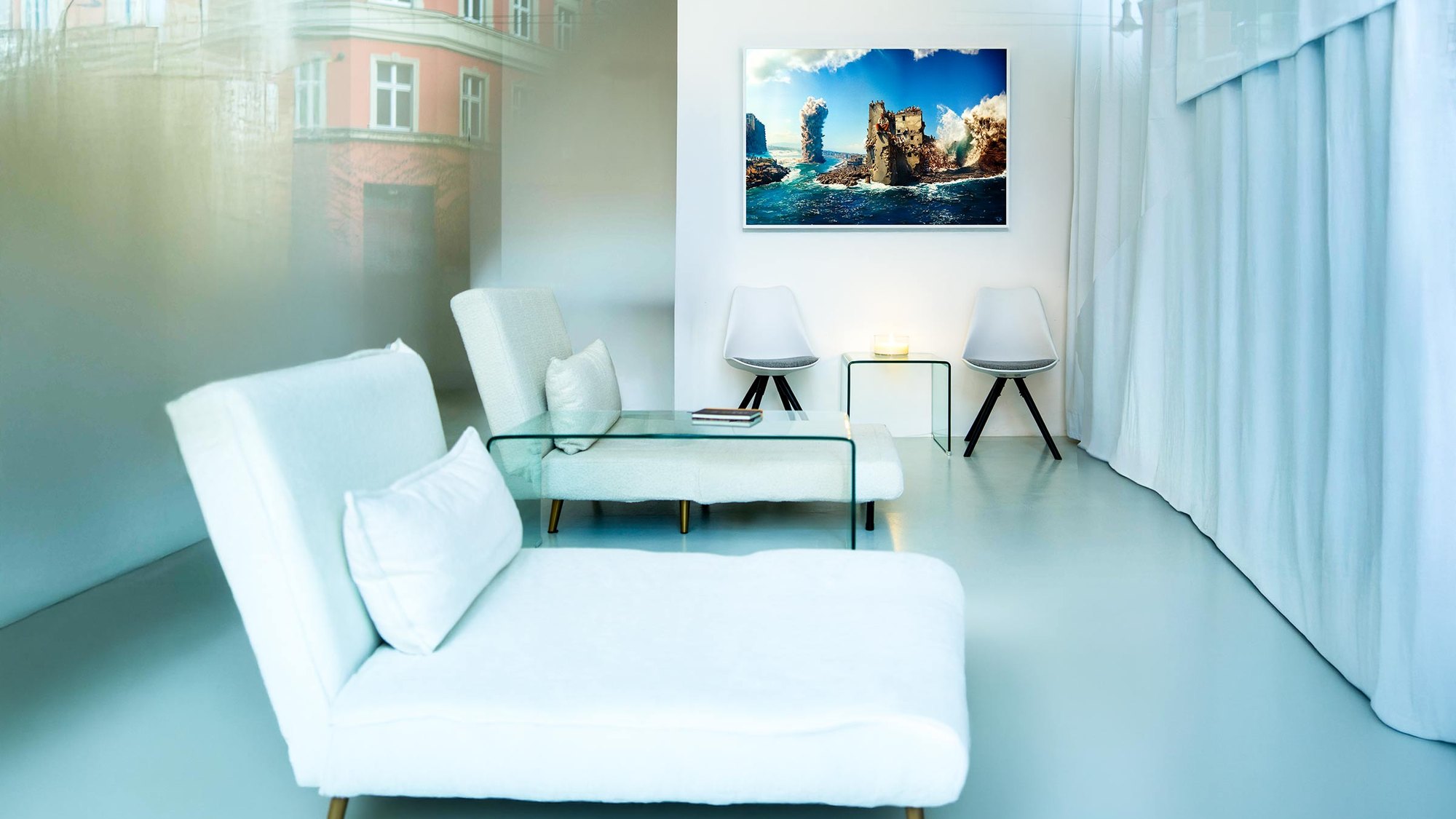 Der Lovelab Dreamspace, Pappelallee 25: weißer Raum mit Tagesbetten, Glastisch und gerahmter Arbeit an der Wand